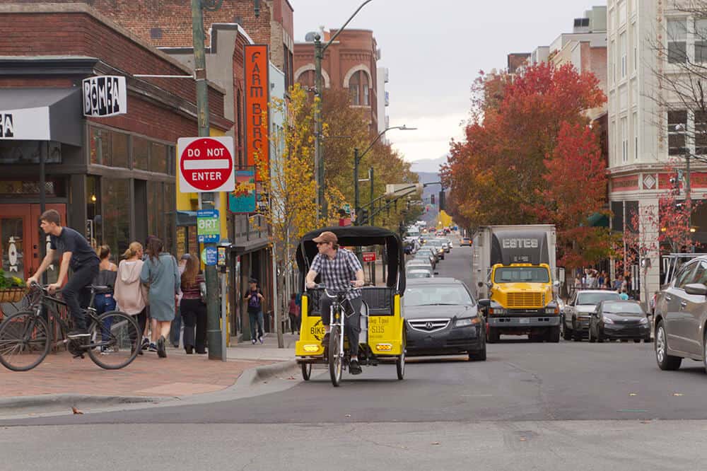 Downtown Asheville Street With Traffic and a Bike Taxi