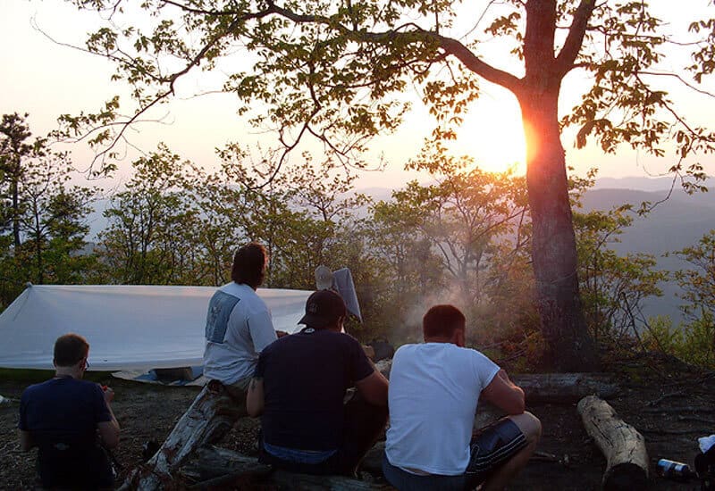 Men camping at sunset